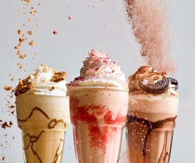Our three new milkshakes. Biscoff on the left, Strawberry Ripple in the middle and Oreo to the right. Topped with whipped cream.